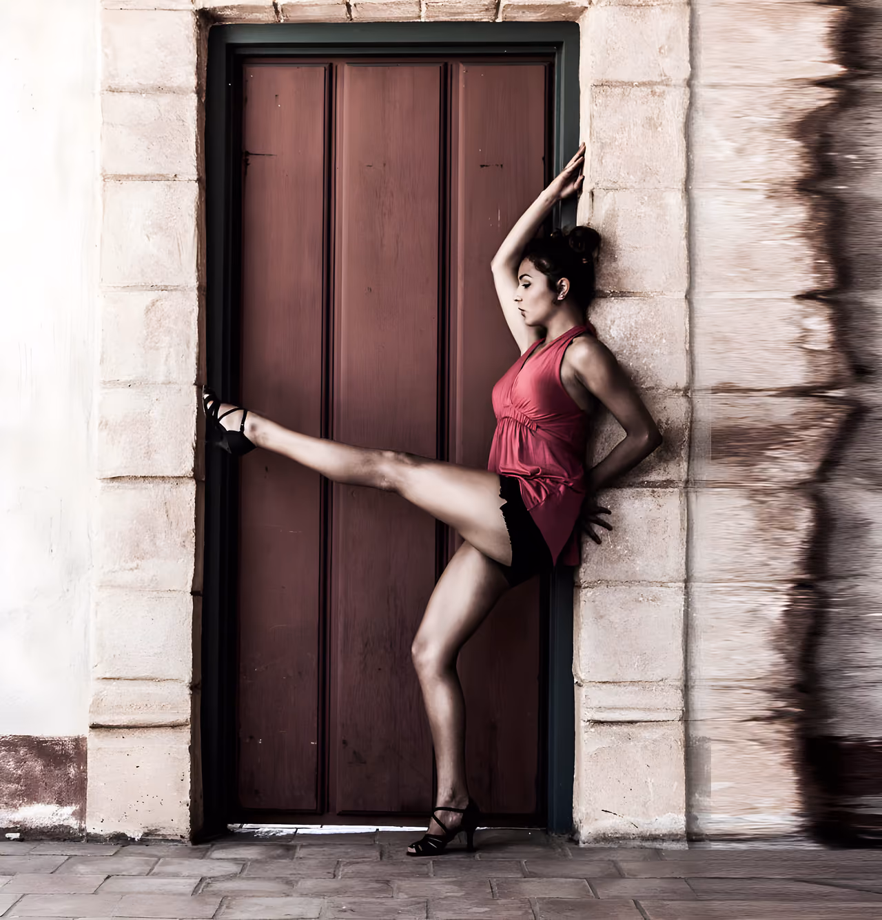 A dancer extends through a high kick in a movement photograph.